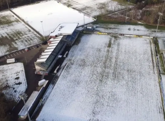 Dronebeeld van besneeuwd voetbalveld in Heist.