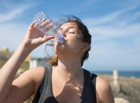 Vrouw drinkt water uit een flesje