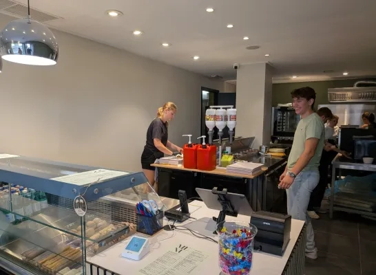 Nora Smets werkende in haar nieuwe broodjeszaak