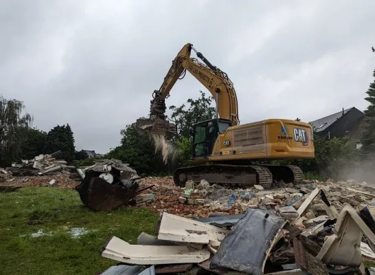 Een aannemer sloopt de leegstaande woningen in Mechelen-Zuid