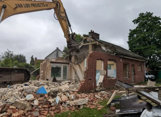 Een aannemer sloopt de leegstaande woningen in Mechelen-Zuid