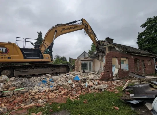 Een aannemer sloopt de leegstaande woningen in Mechelen-Zuid