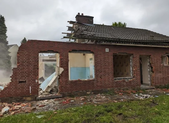 Een aannemer sloopt de leegstaande woningen in Mechelen-Zuid