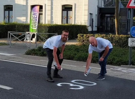 Gemeenteraadsleden Groen Merksplas Jef Schoofs en Jan De Bie tijdens een actie voor de uitbreiding van de zone 30 in de buurt van de kinderopvang
