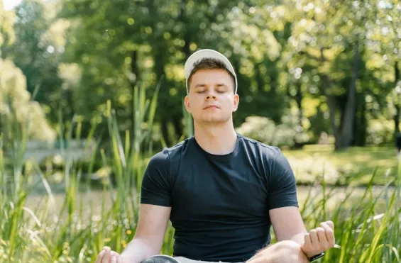 Jonge man mediteert in de natuur